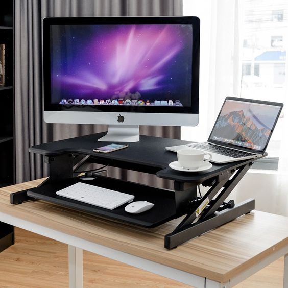a small black height adjustable sit-stand desk with a keyboard tray for any office
