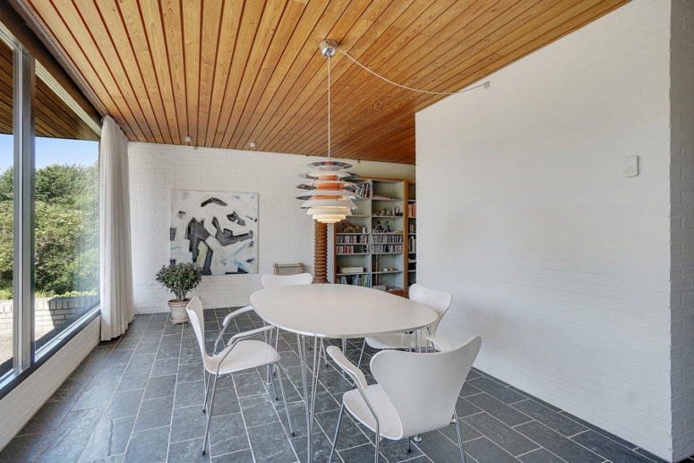 The fireplace wall hides the dining zone with a white dining set and a cool view