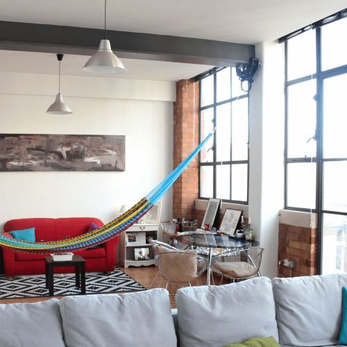 a colorful hammock is a fun and relaxed touch to a plain and usual space