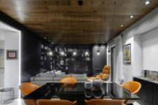 04 The dining space features a black table with a glass top and amber leather chairs