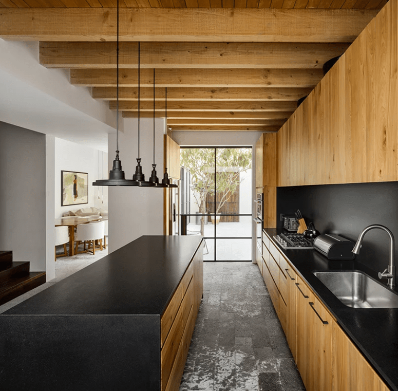 The kitchen was done with dark metal and light-colored wood for a strong contrast