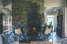 The living room features a cozy hearth clad with stone and some vintage-inspired furniture