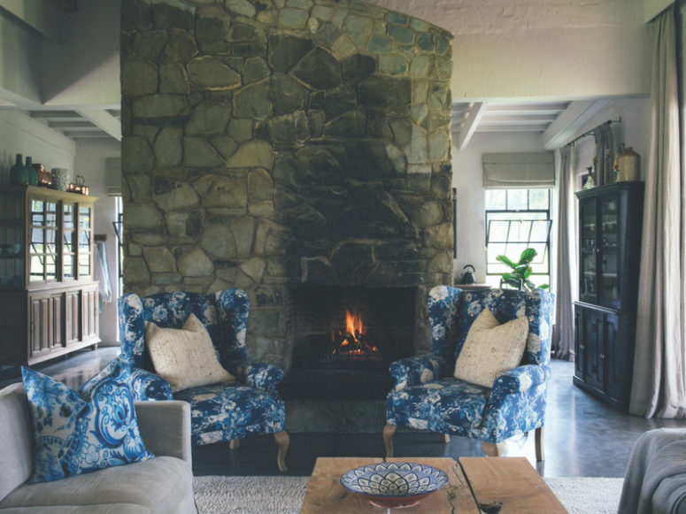The living room features a cozy hearth clad with stone and some vintage-inspired furniture