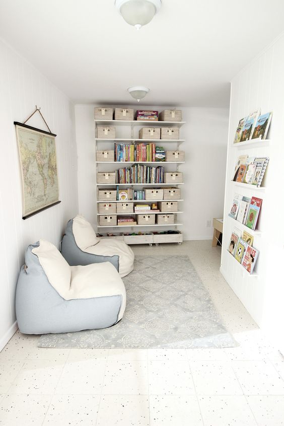 a chic kids' reading nook with lots of books and a couple of cream and blue bean bag chairs