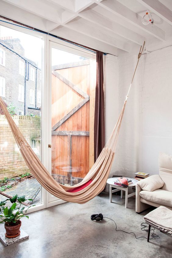 a contemporary to industrial space is done with a beige hammock by an entry to a private courtyard