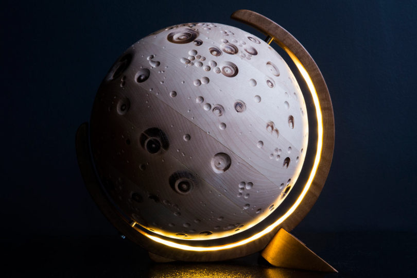 The Moon globe is carved of solid sycamore and resmebles a moon surface
