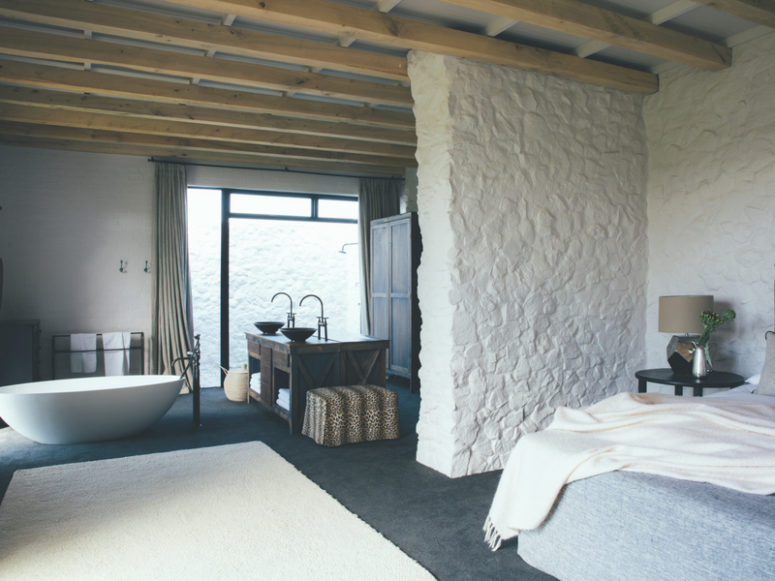 The bedroom includes a bathroom, there's much stone clad and a large double wooden vanity