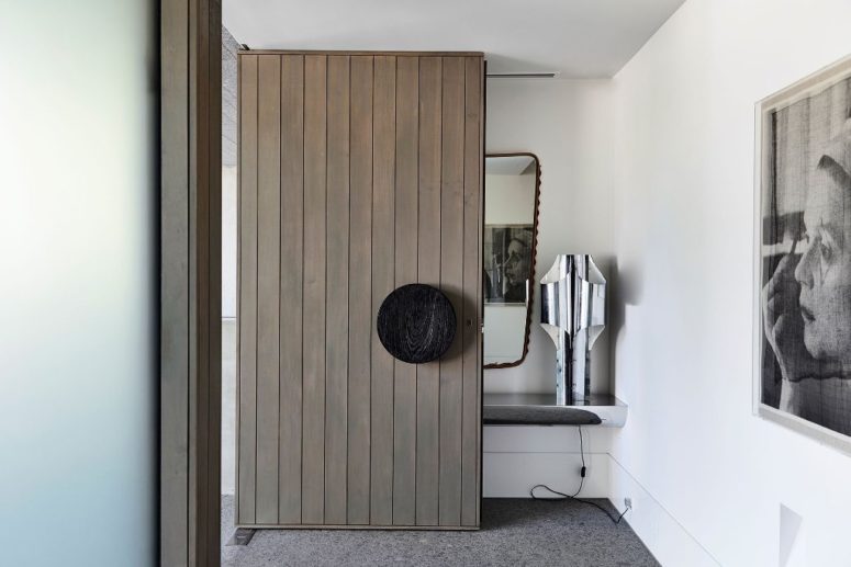 The front door is a statement piece clad with wide wooden planks and with a round knob