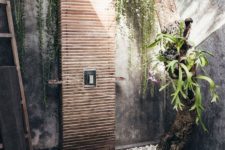 06 a spa-like outdoor shower with pebbles, living plants and a tree and a wooden clad shower and a deck