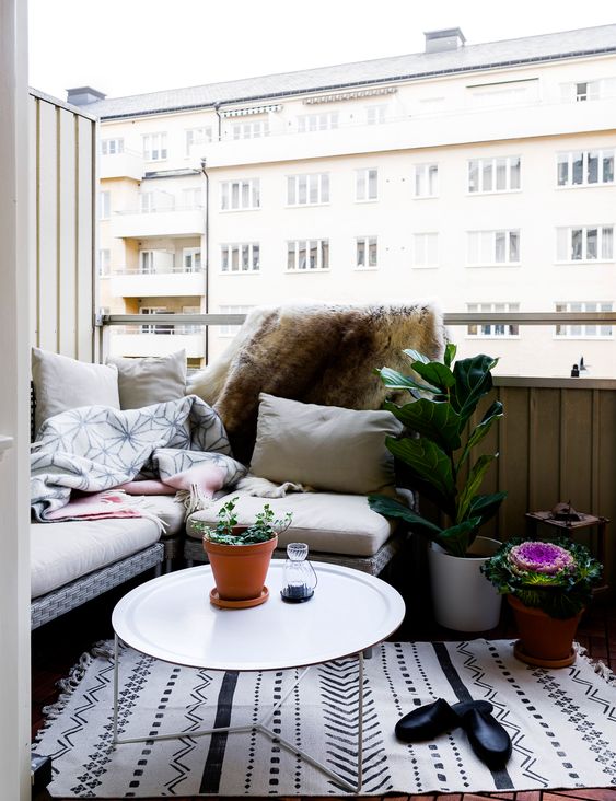 A welcoming nook with an L shaped bench, potted plants and a small coffee table