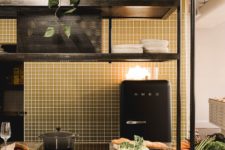 07 The kitchen is a designer’s one, with gold tiles and black touches plus a black Smeg