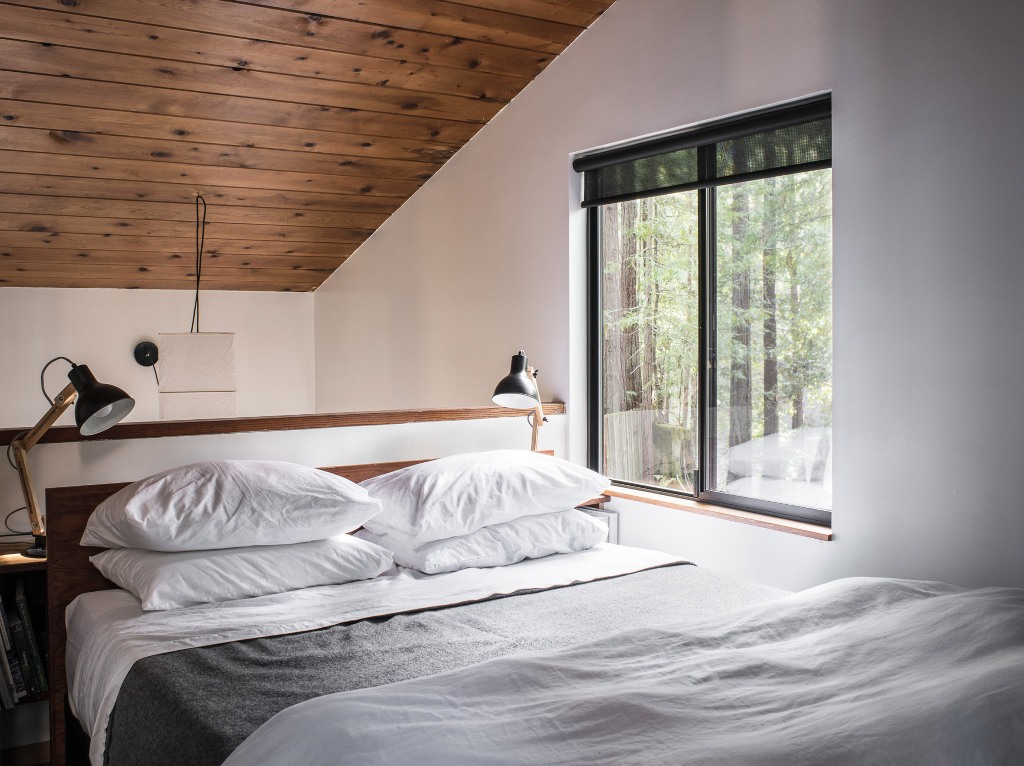 The master bedroom is an attic space with a view, there's a large bed and lots of wood