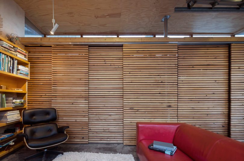 The wall and storage is hidden with wood plank sliding doors to avoid cluttering a small space