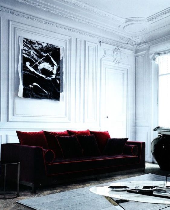 A refined living room with a colorful statement   a burgundy velvet sofa with pillows