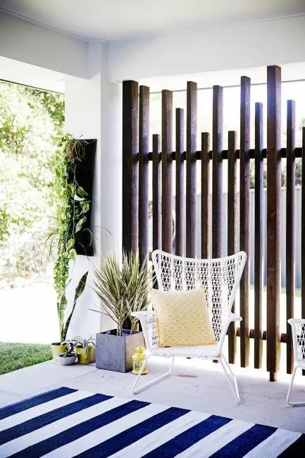 a vertical plank wooden screen is a chic idea for privacy and brings a relaxed feel to the space