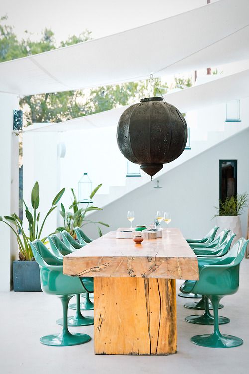 make your outdoor space super trendy with a rough wooden table and sleek plastic chairs in turquoise