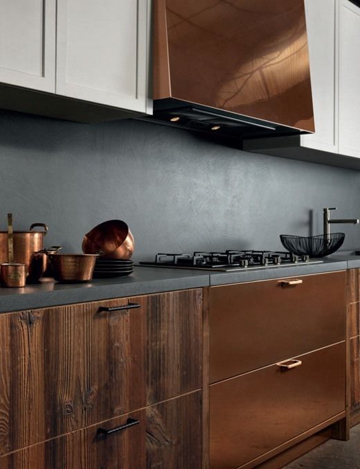 a luxurious kitchen of wood and copper with a concrete backsplash and countertops