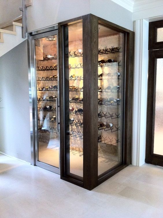 a small yet comfy wine cellar under the stairs with metal holders for bottles on the wall