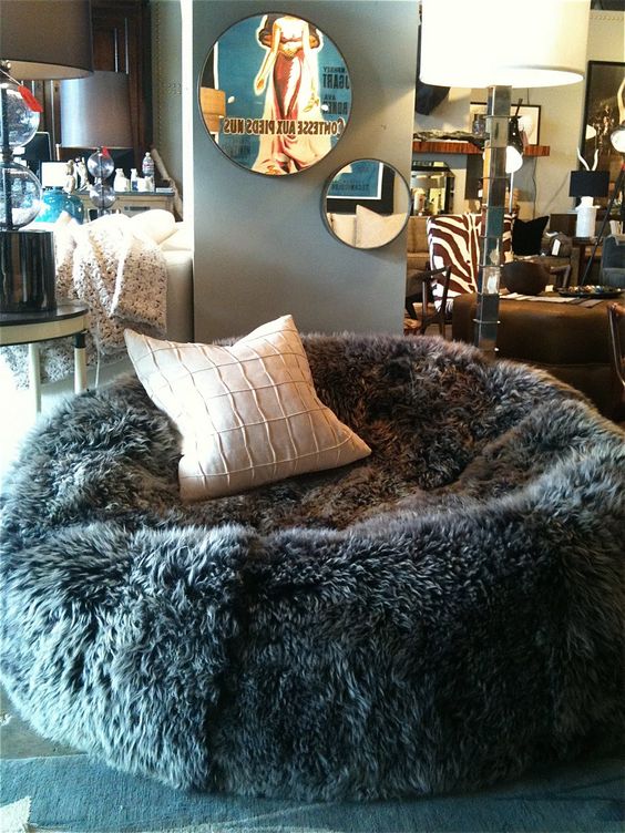 a faux sheep skin bean bag chair with a pillow cna be used both as a chair or as a lounger