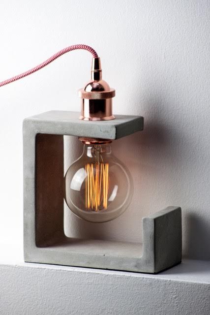 a sculptural concrete table lamps with a copper bulb for a unique look