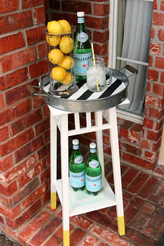 a small bar cart made of an IKEa plant stand and a metal tray is ideal for a tiny outdoor space