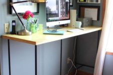12 a large yet simple standing desk of blakc piping and a wooden countertop
