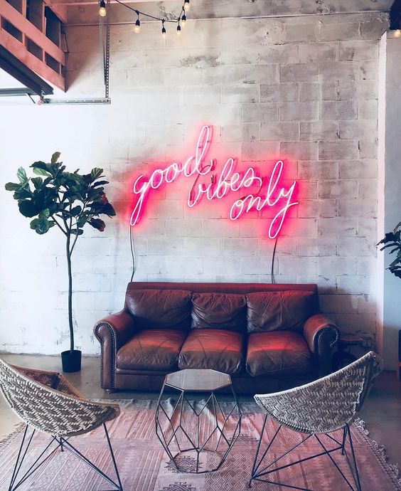 a pink neon light makes this living room bright and softens the industrial space a lot