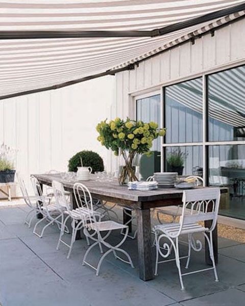a rough wooden table and white refined and elegant forged chairs for a stylish statement