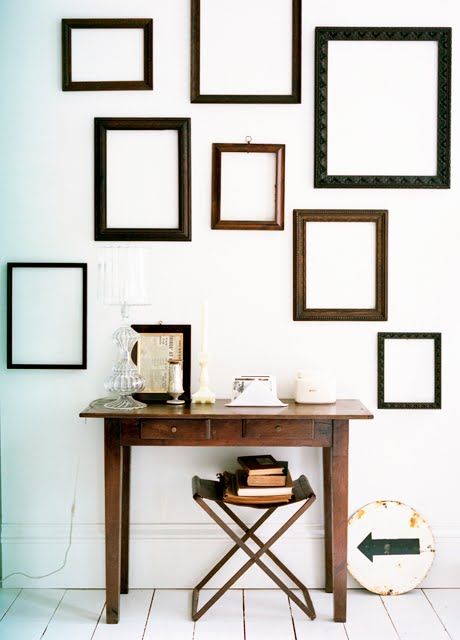 make a statement in a neutral space with dark empty frames and a dark stained desk