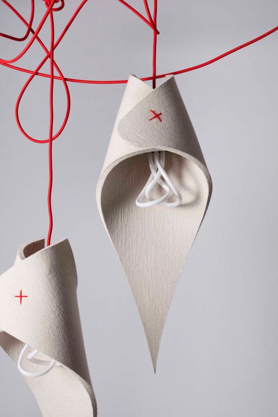 sculptural woolen lamps with red touches and red cords