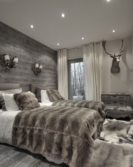 a double guest bedroom done in chalet style with a grey weathered wood wall for a statement