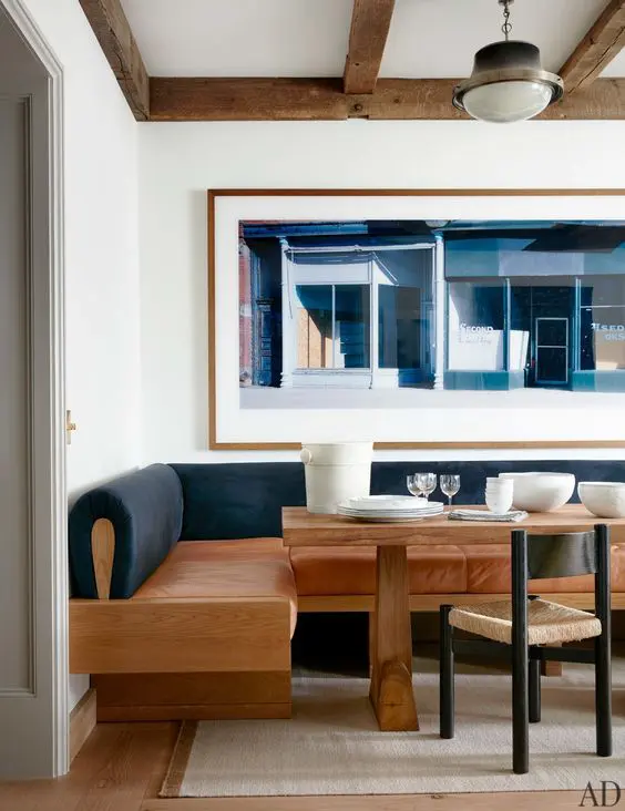 a modern dining space with a wood, leather and velvet banquette in contrasting colors