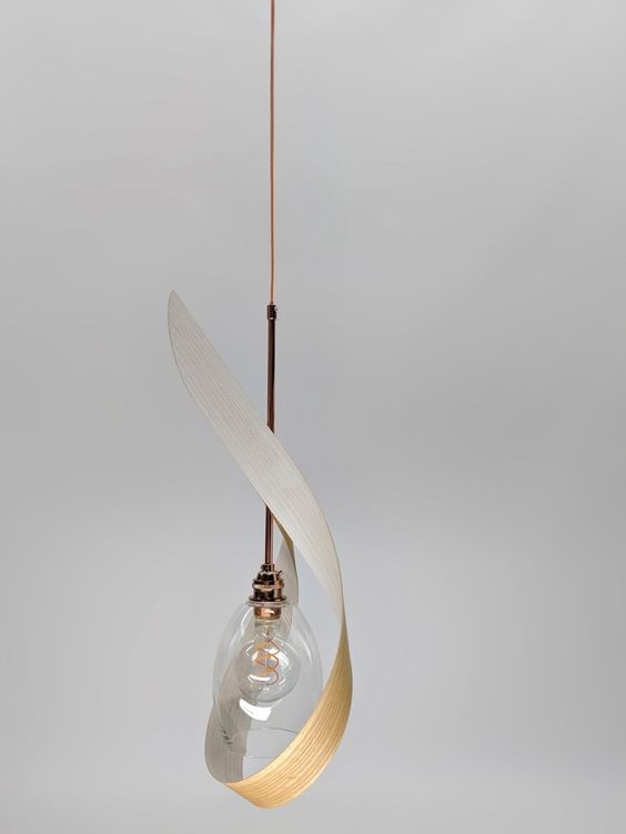 a sculptural pendant lamp made of bent plywood and a glass lampshade