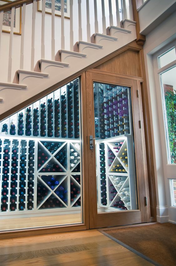 a stylish wine cellar with lots of shelves and additional lights, all done with glass to make it welcoming (designed by  Sorrells)