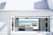 13 an all-white beach house with a folding window, a white bar counter and stools and the same window on another wall to see the views