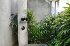 13 an outdoor shower space with a concrete shower spot and a panel plus lots of greenery around