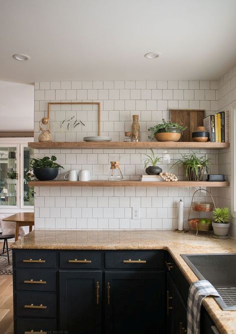 Black cabinets, light colored wooden shelves and brown countertops make up a chic kitchen