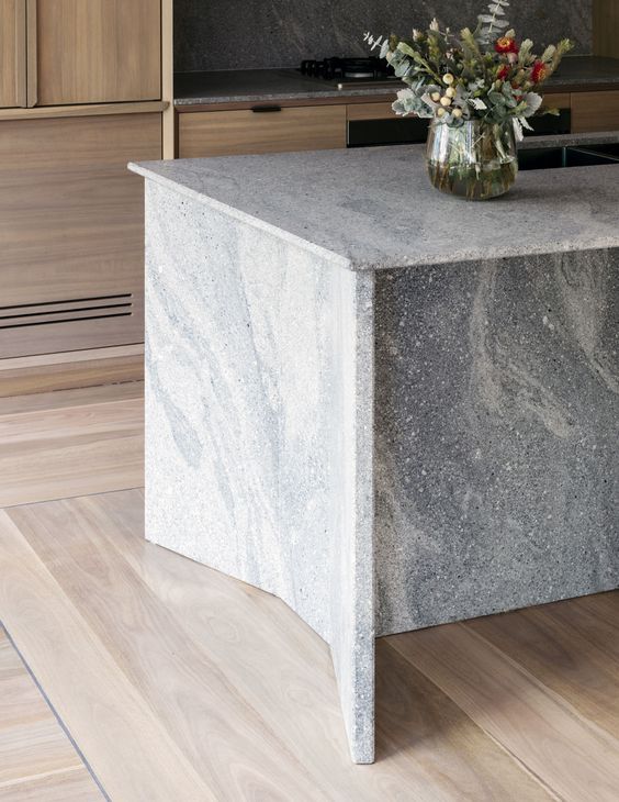 A contemporary space of light colored wood and a grey granite kitchen island for a fresh feel