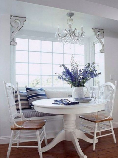 A nautical dining space with a built in banquette seating and a round table