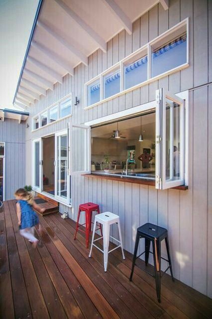 an outdoor bar with a bifold window to the kitchen is a cool space-saving idea