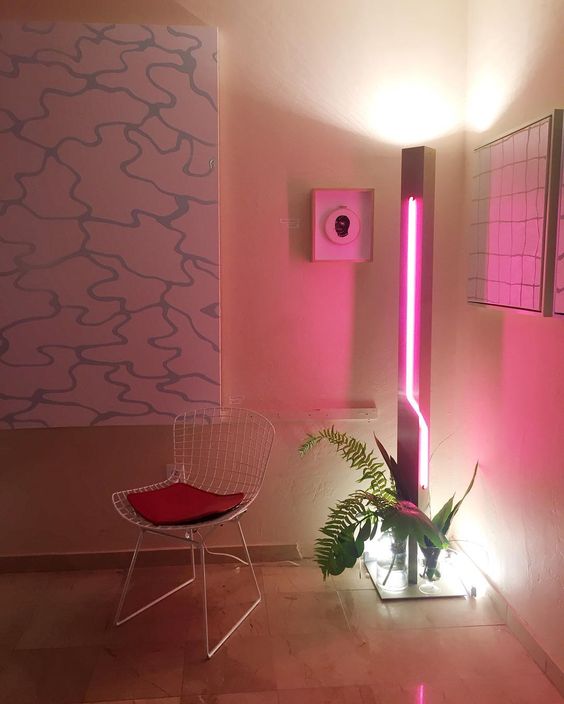 spruce up your space adding a party feel to it with a bright pink neon light and some tropical leaves
