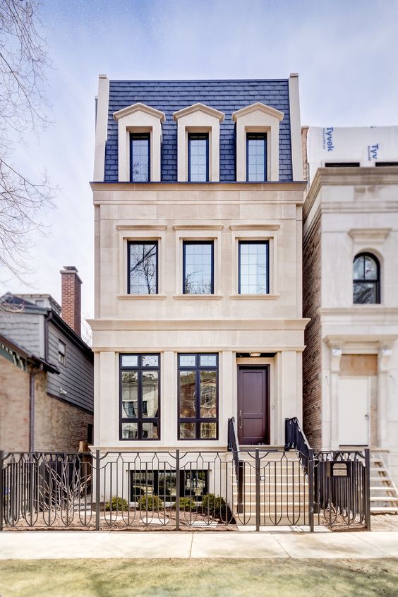 A chic vintage inspired home with a blue shingle mansard roof looks really wow and inspiring