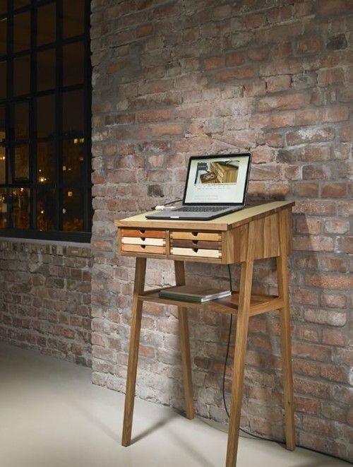 a small wooden standing desk with little colorful drawers is suitable for a laptop