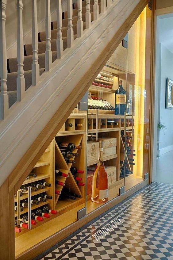 a wine cellar with glass doors and wooden storage units with additional lights to easily find a bottle
