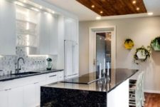 17 a contrasting black and white kitchen with black granite countertops and  touches of wood