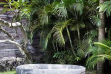 17 a gorgeous tropical outdoor space with only a stone carved bathtub and a metal chair, who needs more