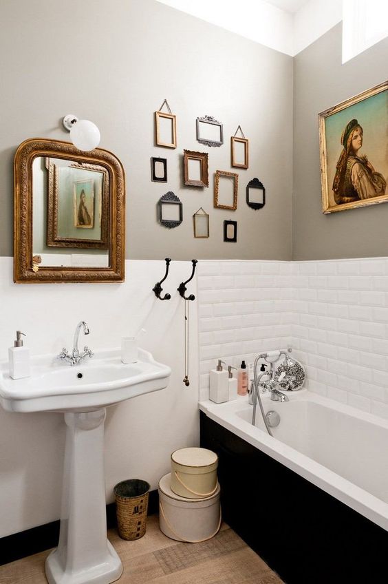 a vintage bathroom done right with an exquisite artwork and some small empty frames