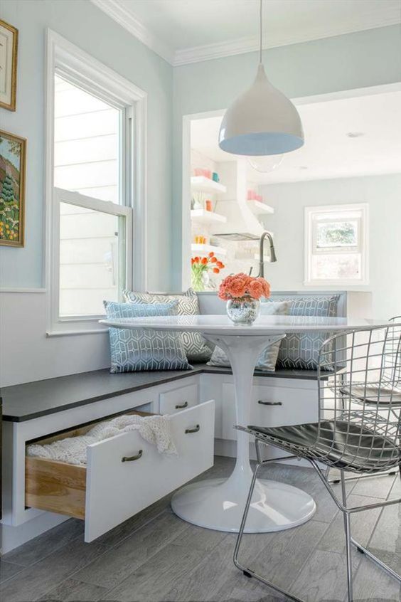 a serene coastal breakfast space with a built-in banquette with drawers for storage