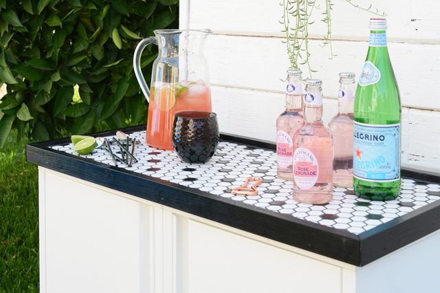 this chic outdoor bar with a mosaic on top is made using IKEA Josef cabinets and looks super chic