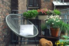 22 a summer balcony with potted greenery and blooms, a chair, a rug and candles